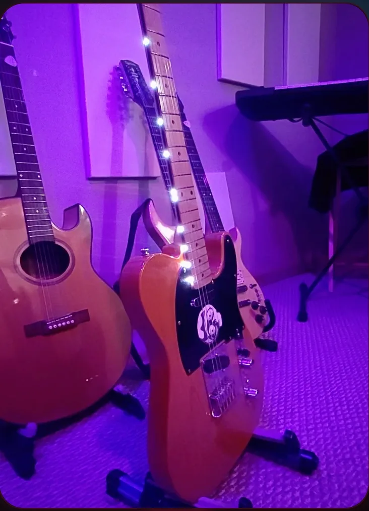 Guitar neck with blue Fret Bright LEDs lit along the fretboard